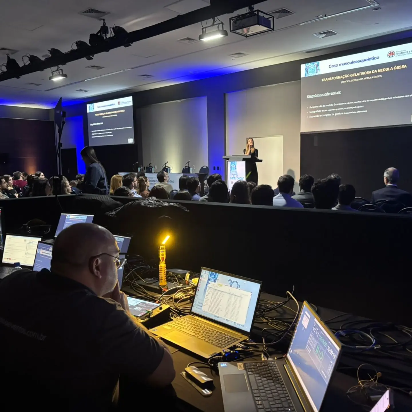 Mesa técnica em frente à plenária principal, com palco, LED e iluminação montados